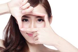 Young woman framing her eyes to highlight vision clarity after refractive lens exchange