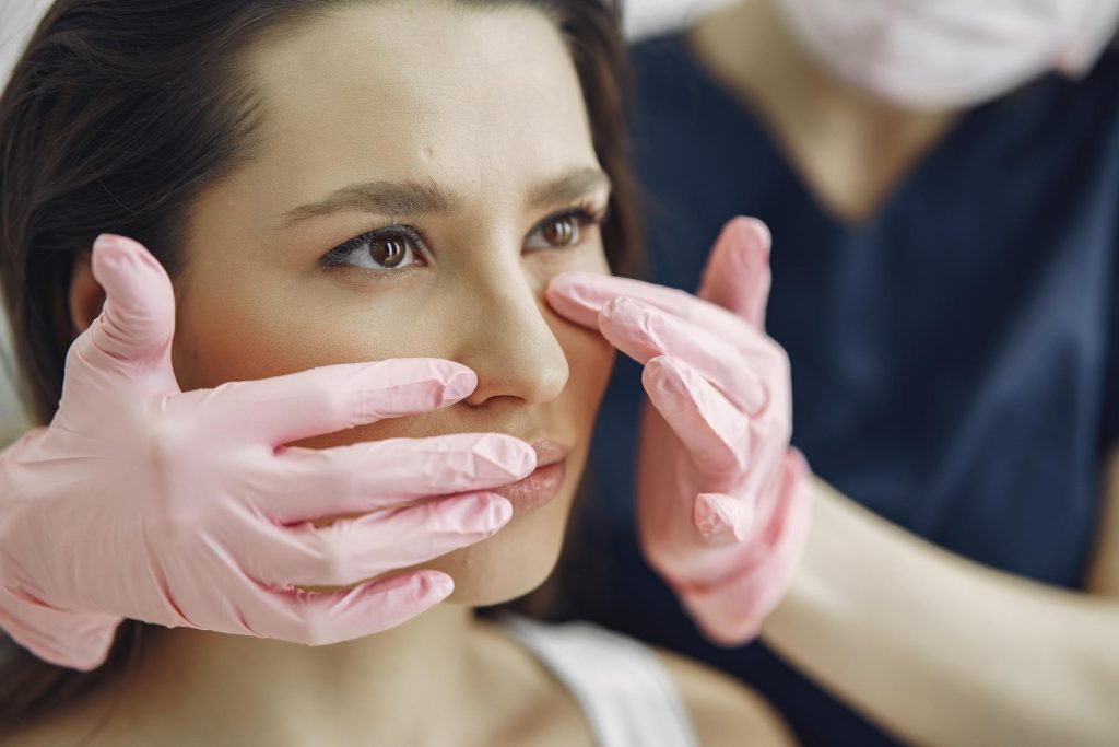 Doctor examining a woman’s eyes, demonstrating assessment for ptosis of eyelid and exploring ptosis meaning in a medical context.