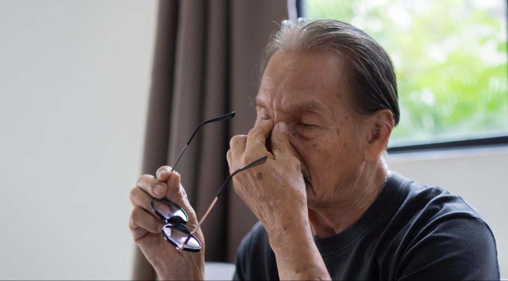 Elderly man experiencing eye strain and discomfort, potentially from glaucoma, illustrating the need for early glaucoma treatment.