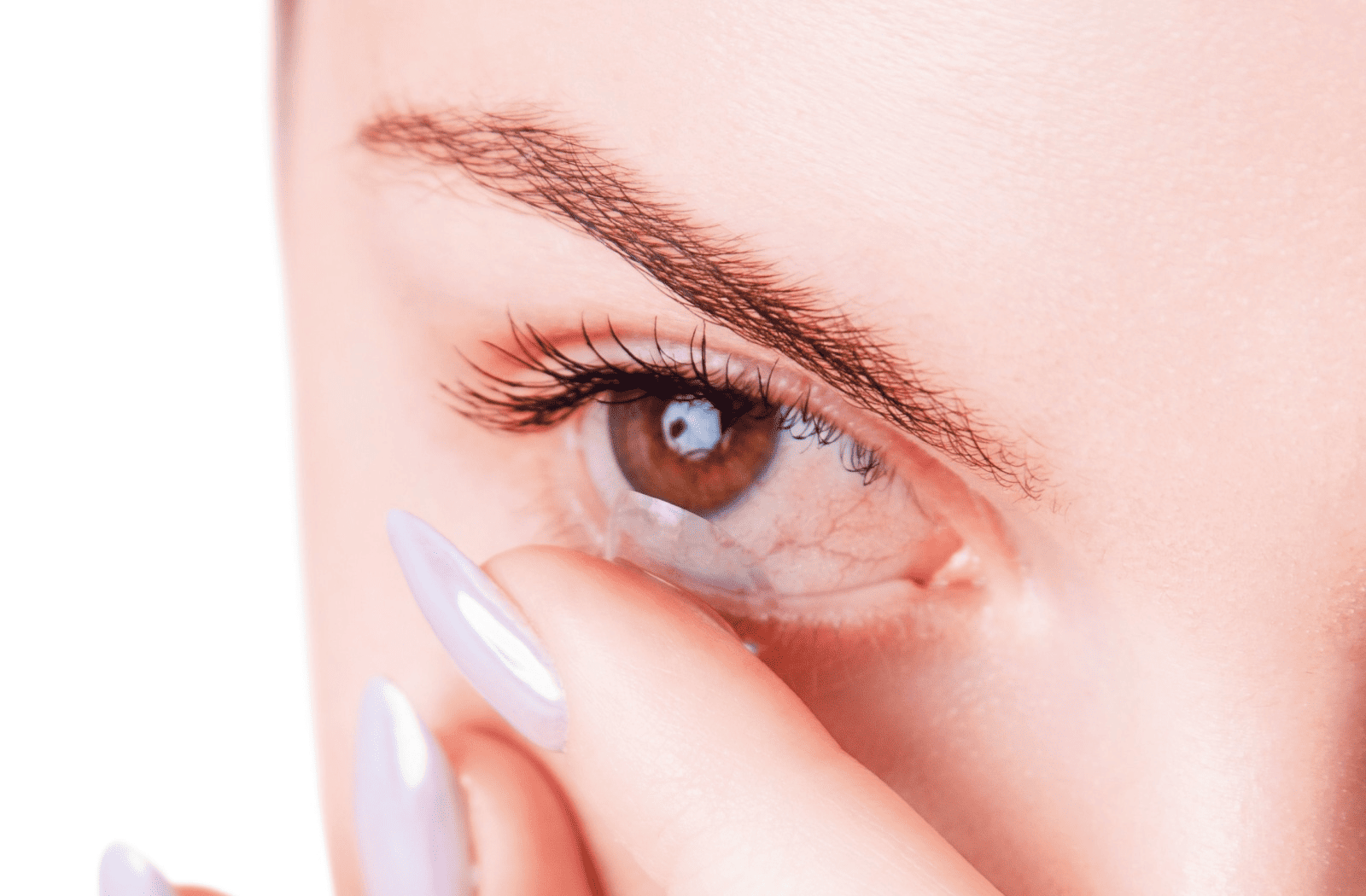 A close-up of a woman pulling down her lower eyelid while touching her eye, showing mild redness