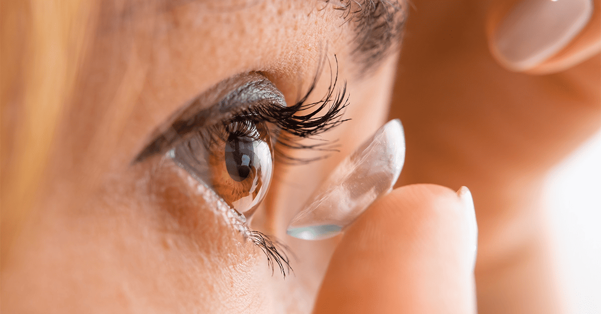 A woman inserting a contact lens into her eye