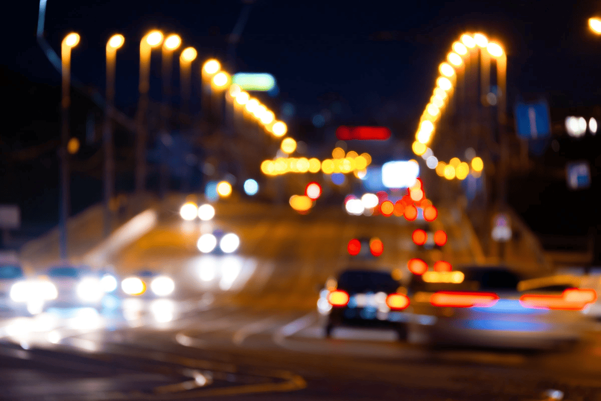 Blurred night traffic lights and car headlights on a busy road